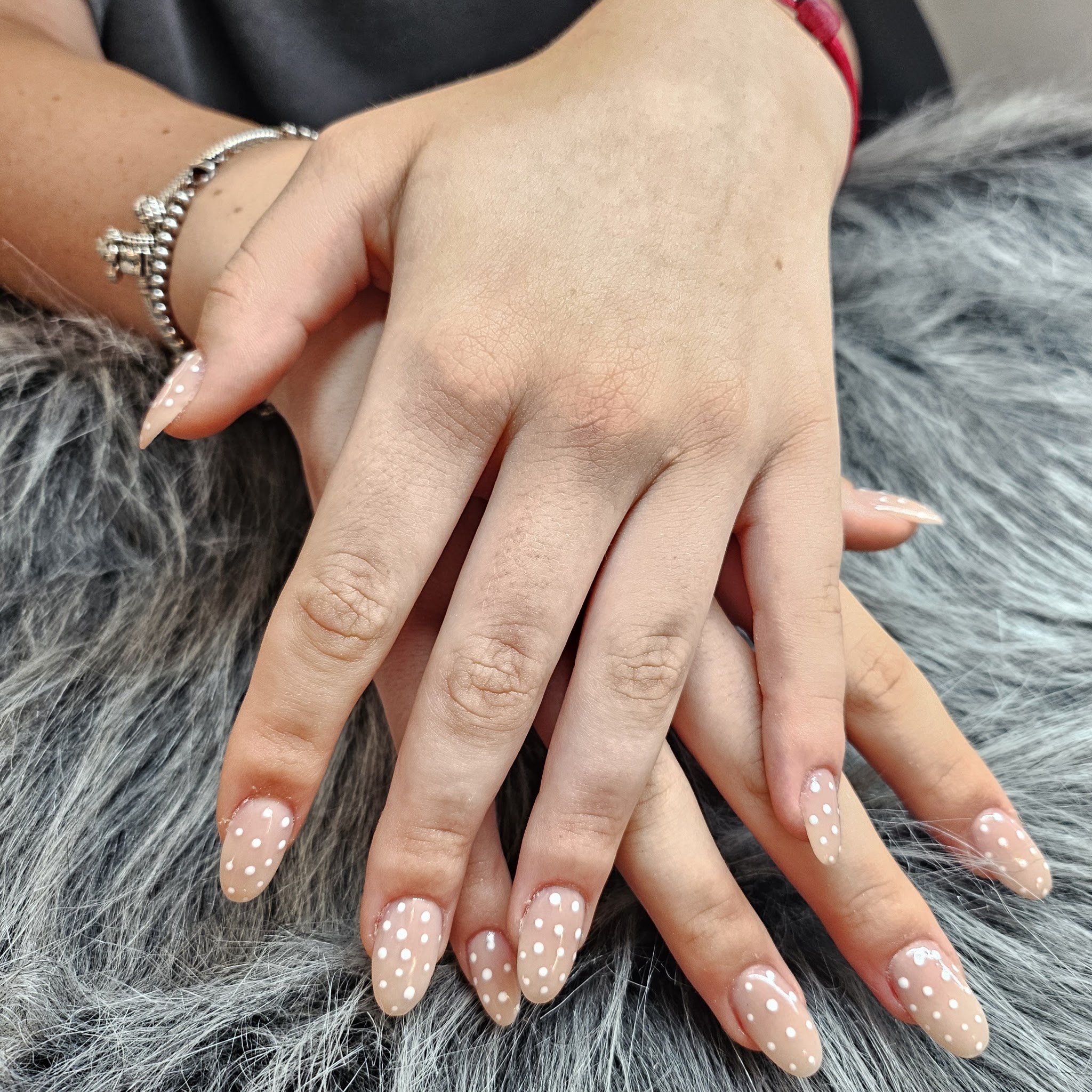 Amandelvormige nude nagels met witte stippen